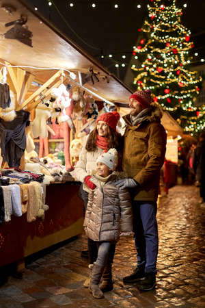 happy family at christmas market in city