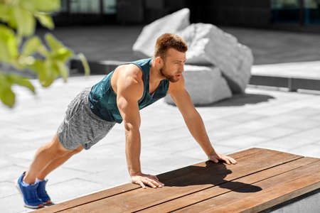 young man doing push ups on city streetの写真素材