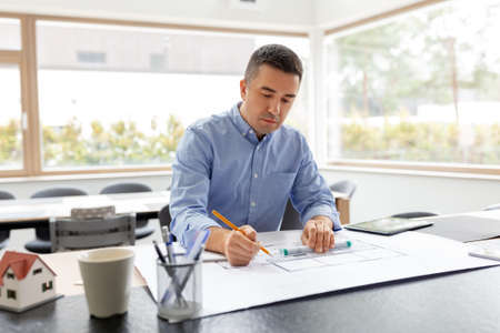 architect with blueprint working at home office