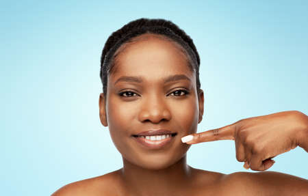 african american woman pointing to her mouth