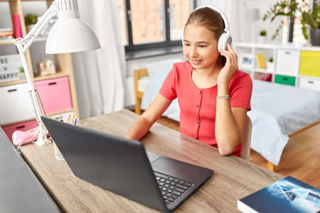girl in headphones with laptop computer at home