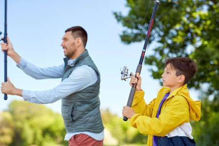 happy smiling father and son fishing on riverの写真素材