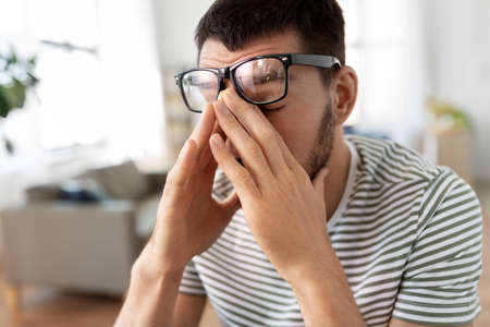tired man with glasses at home officeの写真素材