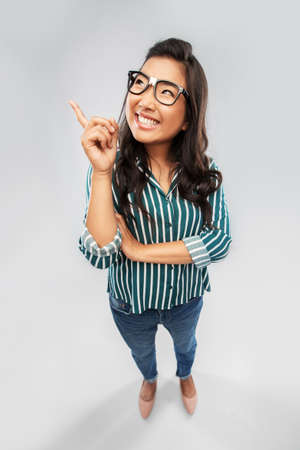 smiling asian student woman pointing finger upの写真素材