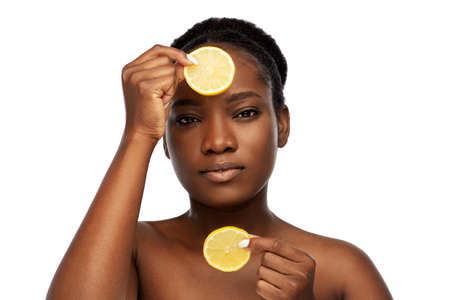 african woman making eye mask of lemonsの写真素材