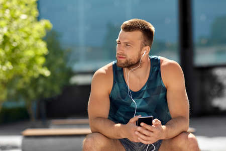 young athlete man with earphones and smartphoneの写真素材