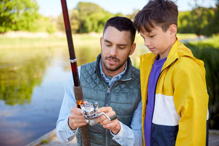 father and son fishing on riverの写真素材