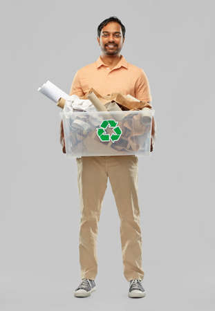 smiling young indian man sorting paper wasteの写真素材