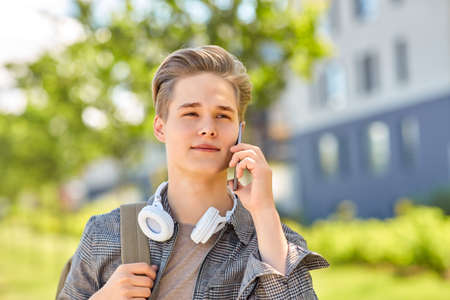 teenage student boy calling on smartphone in cityの写真素材