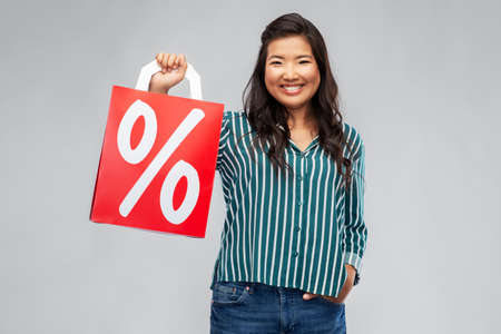asian woman with percentage sign on shopping bagsの写真素材