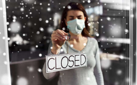 woman in mask hanging banner closed on door