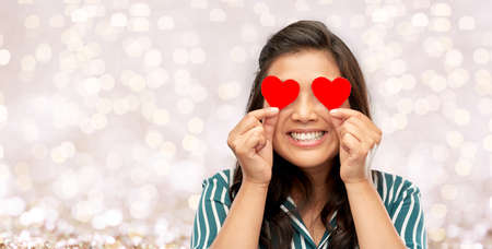 happy asian woman covering her eyes with red heart
