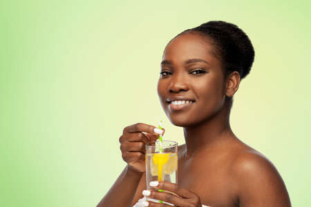 african american woman with glass of fruit water