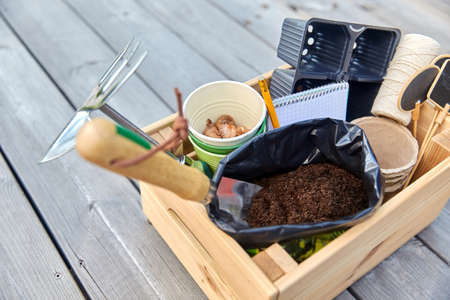 garden tools, soil and pots in wooden box