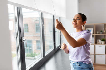 woman opening window roller blindsの写真素材