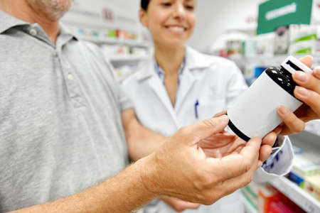 pharmacist and old man with medicine at pharmacyの写真素材