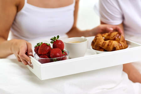 couple having breakfast in bed at homeの写真素材