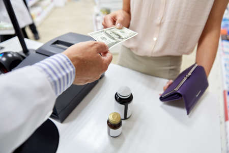 pharmacist taking money from customer at pharmacy