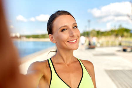 smiling young sporty woman taking selfie picture
