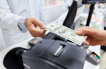 pharmacist taking money from customer at pharmacy