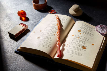 magic book, wax candle, matches and gem stones