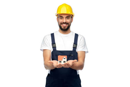 happy male builder holding model of living house