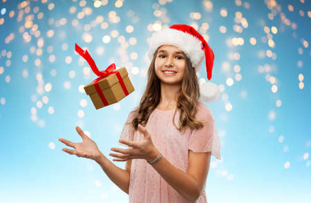 teenage girl in santa hat with christmas gift