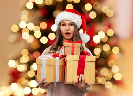teenage girl in santa hat with christmas gift