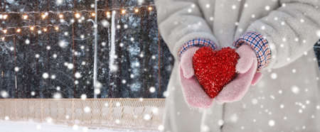 close up of little girl holding heart in winterの写真素材