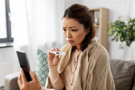 sick woman having video call on smartphone