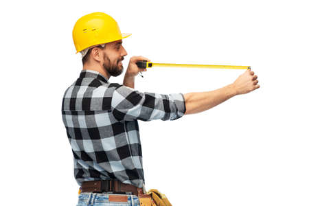 happy male worker or builder in helmet with ruler