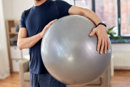 close up of man with fitness ball at homeの写真素材