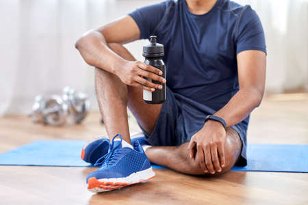 indian man drinking water after training at home