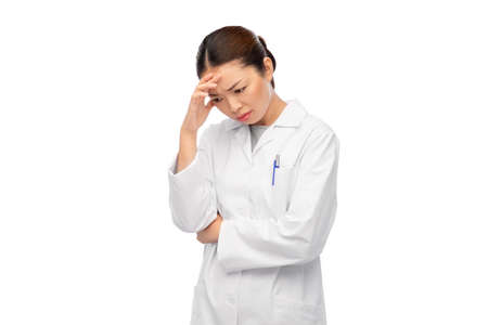sad thinking asian female doctor in white coatの写真素材
