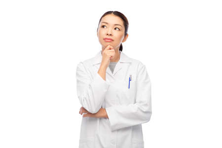 thinking asian female doctor in white coatの写真素材