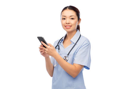 happy asian female doctor or nurse with smartphoneの写真素材