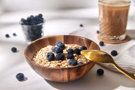oatmeal with blueberries, spoon and coffee
