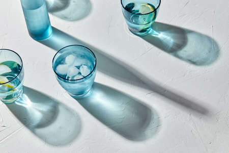 glasses with water and lemons on white backgroundの写真素材