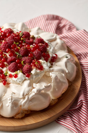 pavlova meringue cake with berries on wooden boardの写真素材