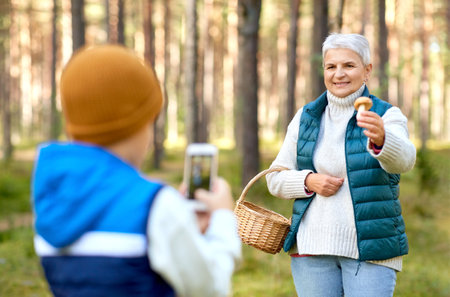 grandson photographing grandmother with mushroom