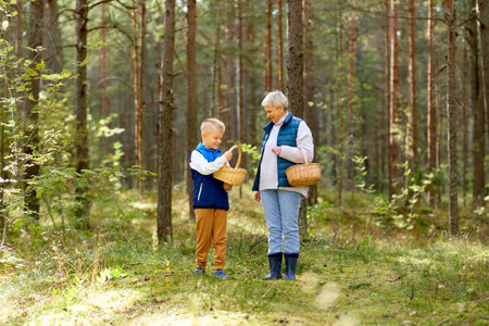 grandmother and grandson with mushrooms in forestの写真素材