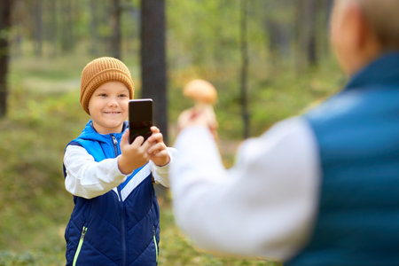 grandson photographing grandmother with mushroomの写真素材