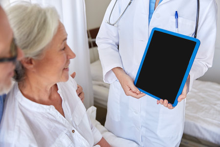 senior woman and doctor with tablet pc at hospitalの写真素材