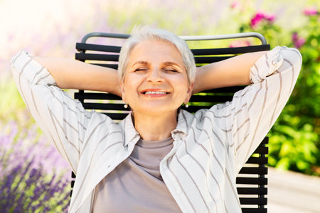 happy senior woman resting at summer gardenの写真素材