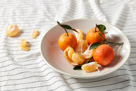still life with mandarins on plate over draperyの写真素材