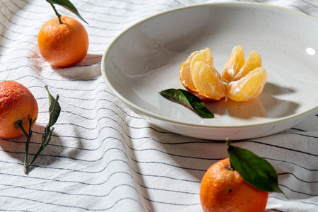 still life with mandarins on plate over drapery