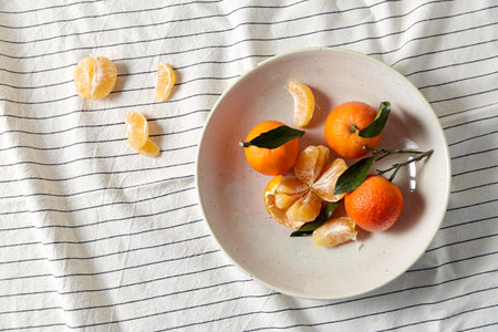 still life with mandarins on plate over draperyの写真素材