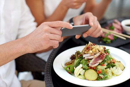 couple with smatphone photographing food