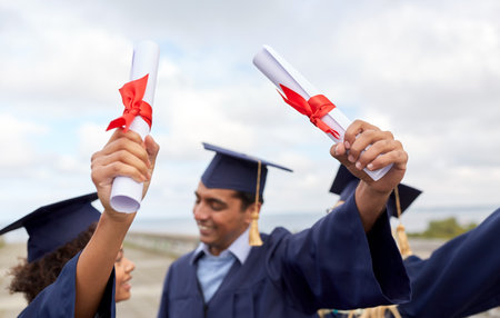 graduate students in mortar boards with diplomasの写真素材