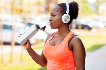 african american woman drinking water after sportsの写真素材